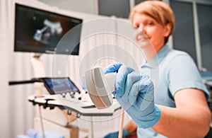 Female doctor holding ultrasound transducer.