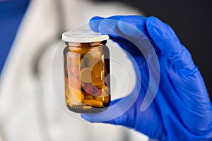 Female doctor holding unlabeled bottle of various pills and medi