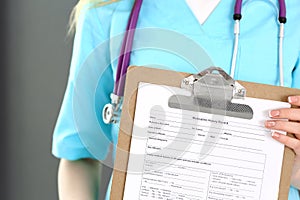 Female doctor holds medication history form while standing straight in hospital closeup. Healthcare, insurance and