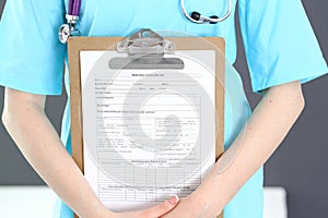 Female doctor holds medication history form while standing straight in hospital closeup. Healthcare, insurance and