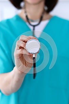 Female doctor holds stethoscope head closeup. Physicians ready to examine and help patient. Medical help and insurance