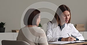 Female doctor holds stethoscope listen to elderly female patient heartbeat