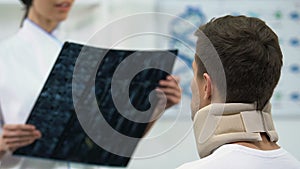 Female doctor informing man in foam cervical collar positive x-ray result