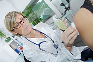 Female doctor injecting medical antidote syringe from glass ampoule