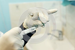 Female doctor injecting medical antidote syringe from glass ampoule close-up, virus cure liquid, hospital healthcare concept