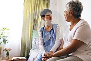 Female doctor interacting with senior female patient
