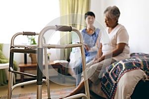 Female doctor interacting with senior female patient at retirement home