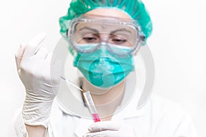 Female doctor in the laboratory with a blood tube for analysis and sampling of Coronavirus under the microscope.