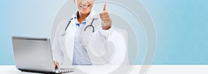 Female doctor with laptop pc showing thumbs up
