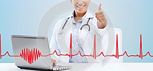 Female doctor with laptop pc showing thumbs up