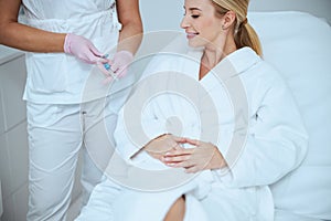 Cosmetologist demonstrating the medical tools before the treatment procedure photo