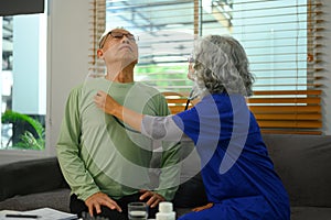 Female doctor listening to patient heartbeat during home visit. Health care concept