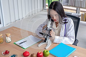 The female doctor is looking at the microscope