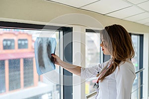 Female doctor looking at x-ray image of lungs radiography