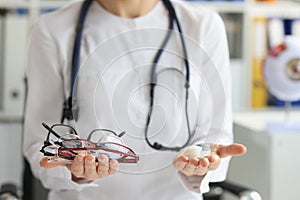 Female doctor making choice between contact lenses and glasses