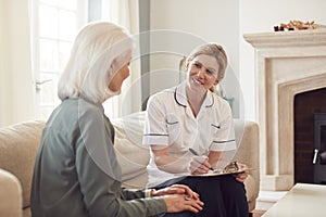 Female Doctor Making Home Visit To Senior Woman For Medical Check