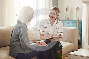 Female Doctor Making Home Visit To Senior Woman For Medical Check