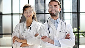 a female doctor and a male doctor are standing in the office with their arms crossed