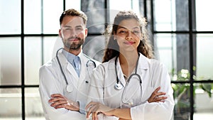 a female doctor and a male doctor are standing in the office with their arms crossed