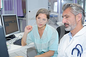 Female doctor with male nurse working at nurses station