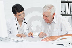 Female doctor with male patient reading reports
