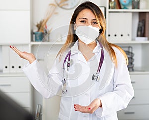 Female doctor in mask welcoming to clinic