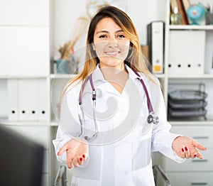 Female doctor in mask welcoming to clinic