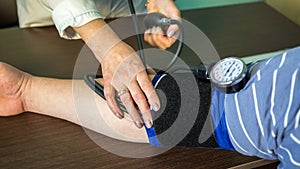 Female doctor measures blood pressure in a patient