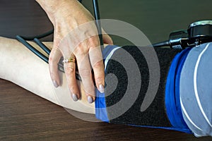 Female doctor measures blood pressure in a patient