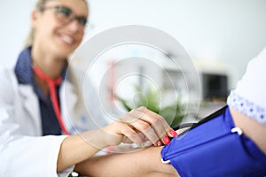 Female doctor measures pressure of a patient closeup