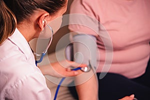 Female doctor measures woman`s blood pressure with tonometer