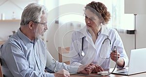 Female doctor measuring blood pressure of elderly male patient