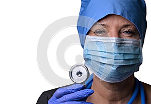 A female doctor in a medical mask and blue medical gloves holds a stethoscope  in her hands and looks at the camera