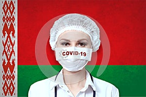 Female doctor in medical mask with the inscription COVID-19 on a blurred background of the flag of  Belarus. Pandemic virus COVID-