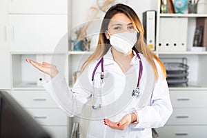 Female doctor in medical mask inviting to doctor& x27;s office