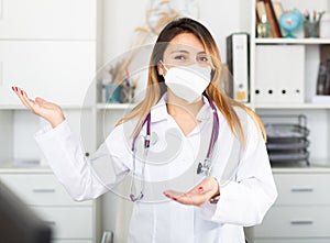 Female doctor in medical mask inviting to doctor& x27;s office