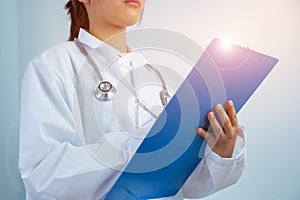 Female doctor medical physician writing prescription clipboard with record information paper over with gown suite wearing