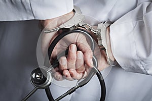 Female Doctor or Nurse In Handcuffs Holding Stethoscope