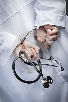 Female Doctor or Nurse In Handcuffs Holding Stethoscope