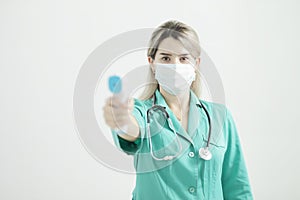 Female doctor or nurse at hospital holds pyrometer in hand