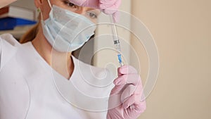 Female doctor, nurse in hospital shows the syringe with liquid medicine. Healthcare and medical concept. slow motion