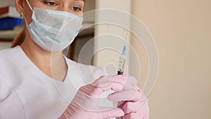 Female doctor, nurse in hospital shows the syringe with liquid medicine. Healthcare and medical concept. slow motion