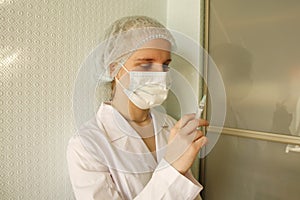 Female Doctor Or Nurse In Mask Holding Syringe