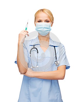 Female doctor or nurse in mask holding syringe