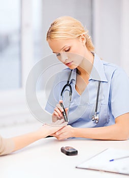 Female doctor or nurse measuring blood sugar value