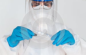 Female doctor or nurse in protective suit takes a specimen swab