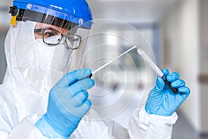 Female doctor or nurse in protective suit takes a specimen swab