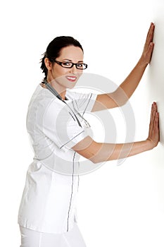 Female doctor or nurse pushing or leaning on wall