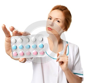 Female doctor offering pack of pills capsules blue to the patient in hand