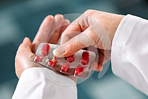 Female doctor offering red tablets to patient